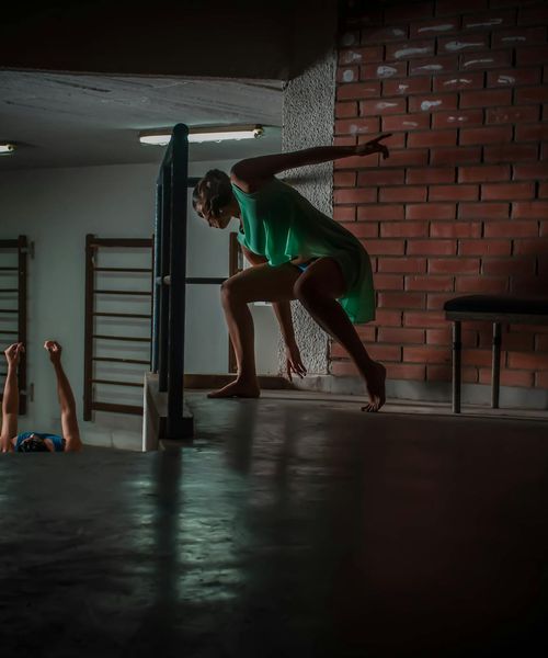 Woman performing a light cardio exercise in a dark room with cyan light accents.